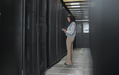 Image showing Tablet, server room and data center with a programmer asian woman at work on a computer mainframe. Software, database and information technology with a female coder working alone on a cyber network