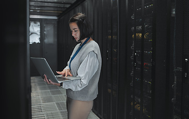 Image showing Server room, laptop and technician woman for data center management, system update and cyber security. Focus, serious and inspection of asian electrician, engineering or programmer person typing code