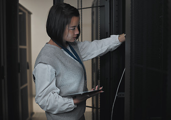 Image showing Tablet, server room and engineering with a programmer asian woman at work on a computer mainframe. Software, database and information technology with a female coder working alone on a cyber network