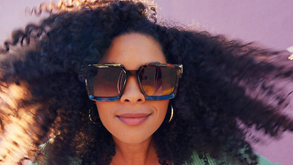 Image showing Hair care, fashion sunglasses and black woman happy in summer, smile for summer curls and excited about luxury glasses against pink city wall. Portrait of comic girl with curly hair on street