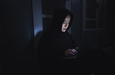 Image showing Hacker, server room and person on laptop for coding software, data center crime and cyberpunk in dark. Network hacking, woman or user in cybersecurity, information technology or programmer ransomware