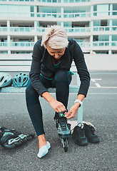 Image showing Roller skate, tie and senior woman in city ready for sports, adventure and fitness hobby outdoors. Exercise, holiday and elderly female tying shoelace from skating, travel and journey in road