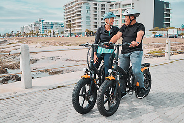 Image showing Senior couple, electric bike and ride by the beach for fun bonding activity or travel together in the city. Happy elderly man and woman enjoying cruise on electrical bicycle for trip in Cape Town