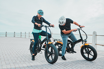 Image showing Mature couple, electrical or checking bike by beach in bonding transportation, clean energy or sustainability city travel. Ebike, electricity or eco friendly bicycle for elderly man or cycling woman