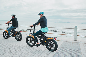 Image showing Couple, helmet or electrical bike by sea or ocean beach in bonding transport, clean energy or sustainability travel. Technology, electric or eco friendly bicycle for happy woman or mature cycling man