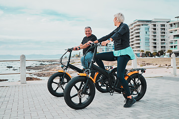 Image showing Mature couple, electrical and bike by ocean, beach or sea in bonding transportation, clean energy or sustainability travel. Ebike, electricity and eco friendly bicycle for happy man or cycling woman