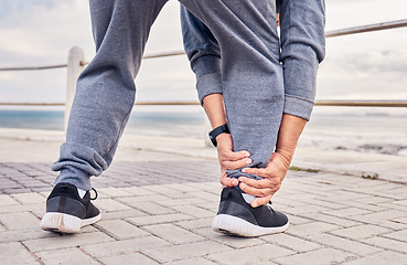 Image showing Ankle, pain and man exercise outdoor at beach with medical risk, sports wound and fitness. Male runner, foot injury and joint problem of body muscle, first aid and health emergency at ocean promenade