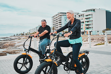 Image showing Senior couple, electric bike and smile by the beach for fun bonding cycling or travel together in the city. Happy elderly man and woman enjoying cruise on electrical bicycle for trip in Cape Town