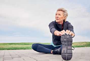 Image showing Woman, stretching exercise and fitness on blue sky mockup, park ground and training for cardio wellness. Senior female warm up legs outdoor for workout, sports running and thinking of healthy body