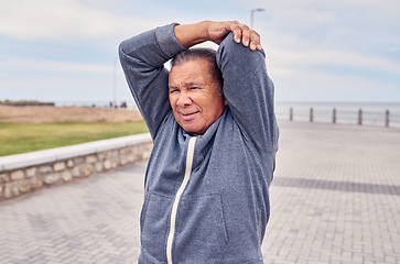 Image showing Senior man, exercise and stretching arms at promenade beach for fitness, wellness or training. Male warm up body outdoor for workout, sports performance and start healthy cardio marathon of mobility