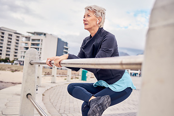 Image showing Fitness, music and stretching with a senior woman getting redy for a cardio workout on the promenade. Exercise, warm up and running with a mature female athlete in preparation on an early morning jog