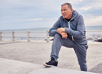 Image showing Senior man, fitness and stretching at beach sidewalk for energy, wellness and healthy cardio workout. Elderly male, exercise and rest at seaside promenade for training, sports and breathing outdoor