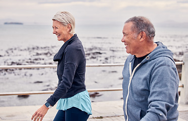 Image showing Walking, fitness and senior couple smile by ocean for exercise, healthy body and wellness in retirement. Sports, relax and happy elderly man and woman ready for warm up, cardio workout and training
