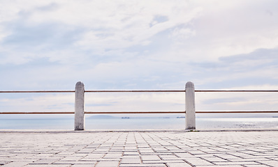 Image showing Morning, beach and view of ocean from the promenade of the water, nature and landscape in Italy. Travel, natural and peaceful tourism site by the sea to relax and be calm on the coast for traveling