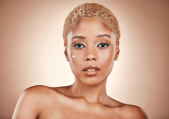 Image showing Beauty, skincare and portrait of black woman with cream on face in studio with mockup, luxury cosmetics and glowing skin. Natural makeup, spa facial and golden aesthetic on model on brown background.