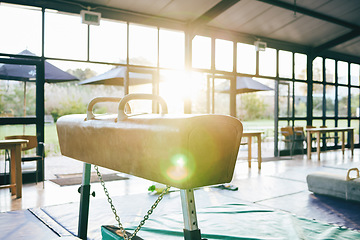 Image showing Gymnastics pommel horse in gym, exercise and lens flare, fitness equipment and training for sports competition. Sport equipment to test athlete strength and balance, workout studio with gymnast club