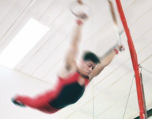 Image showing Gymnastics, ring and fitness with man in stadium and focus for sports, workout or health. Wellness, exercise and training with athlete and still rings in gym arena for strong, power and motion blur