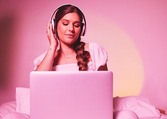 Image showing Pink, light and laptop by woman in a bed with music, social media and streaming on wall background. Podcast, website and girl relax in bedroom, happy and enjoying radio, audio or online playlist