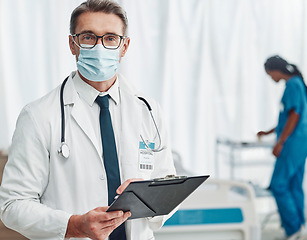 Image showing Covid, leadership and portrait of doctor with clipboard, man in hospital for support in medical work. Health, insurance and medicine, mature professional with stethoscope, mask and patient chart.