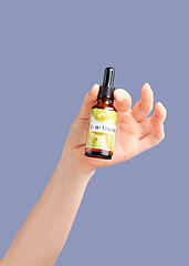 Image showing Skincare treatment, model hands and essential oil serum with product bottle for dermatology. Studio beauty, wellness and self care with hyaluronic acid for collagen production with purple background
