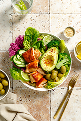 Image showing Salmon avocado bowl with broccoli, olives and fresh salad. Healthy food, keto diet, top view