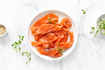 Image showing Salted salmon sliced on plate on a white background, top down view