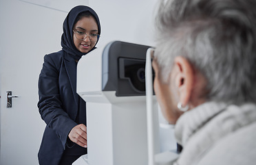 Image showing Optometrist, muslim woman and testing eyesight health in optometry lab with optical machine indoors. Senior patient in eye clinic, person at appointment to scan diagnosis and ophthalmologist working