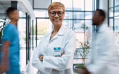 Image showing Portrait, healthcare and motion blur with a doctor black woman standing arms crossed in a busy hospital. Medical, insurance and trust with a female medicine professional in a clinic for treatment