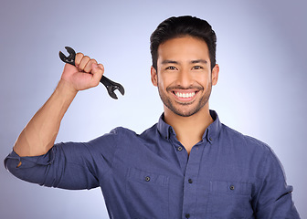 Image showing Portrait of man holding wrench isolated on studio background for repair solution, maintenance or plumbing. Professional worker, asian person or happy plumber with mechanic tools hand in job success