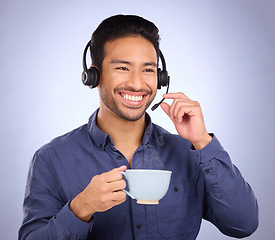 Image showing Happy call center man isolated on studio background for technical support, communication services and coffee for productivity. Asian consultant, business agent or person talking on a headset with tea