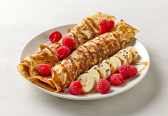 Image showing freshly baked crepes with fruit and caramel sauce