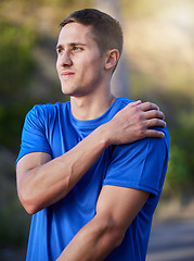 Image showing Injury, sport and man holding an arm with pain during running, exercise and strain from cardio. Health, accident and athlete runner with an injured muscle, painful body and inflammation in nature