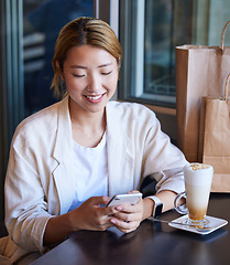 Image showing Phone, cafe and woman online shopping, ecommerce or social networking with customer services review. Asian person on smartphone at coffee shop or restaurant and happy with retail sale or discount