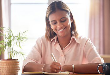 Image showing University, planning and woman student writing in a notebook working on a school project in her home. Education, happy and female college scholar from Mexico studying for a test or exam in apartment.