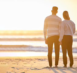 Image showing Couple, beach and holding hands at sunset for love and peace with a calm ocean on vacation. Young man and woman together on holiday at sea to relax, travel and connect in nature for freedom mockup