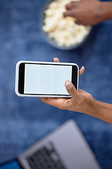 Image showing Hands, phone and mockup screen above with popcorn for social media, entertainment or streaming at home. Vertical hand of person holding mobile smartphone with display for app advertising or branding