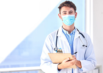 Image showing Portrait, covid and mockup with a doctor man writing on a clipboard in a hospital for insurance. Medical, healthcare and checklist with a male medicine professional completing documents for admin