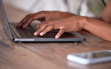 Image showing Hands, laptop and typing on wooden table for communication, email or social media. Hand of African American freelancer working remote on computer keyboard for research, browsing or networking on desk