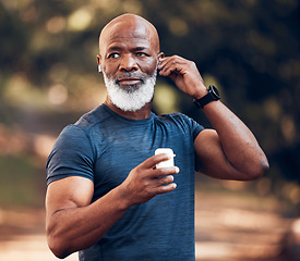 Image showing Black man, wireless earphones and running outdoor in park, nature or garden for healthy workout. Senior sports male listening to music to start training with radio, fitness and motivation of exercise