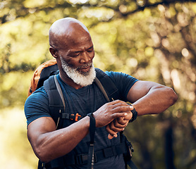 Image showing Fitness, mature and black man reading time while walking, running or trekking in nature. Exercise, training and senior African person with watch for physical activity progress and heart rate monitor