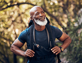 Image showing Nature, backpack and senior black man hiking in a forest for exercise, health and wellness. Sports, athlete and happy elderly African male hiker in retirement trekking in the woods on adventure trail
