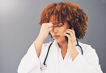 Image showing Woman doctor on phone call stress, headache or anxiety for healthcare problem isolated on gray background. Tired, burnout and medical professional or nurse with pain, frustrated or angry on cellphone