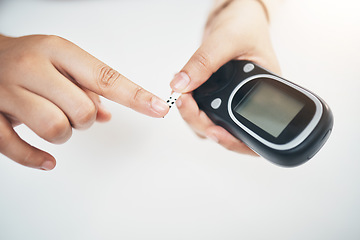Image showing Diabetes, hands of black woman and blood test strip on finger, healthcare and medicine in home. Health, innovation and technology, diabetic person with digital hand glucometer checking glucose level.