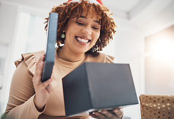 Image showing Christmas, gift and celebration with a business black woman opening a box at an office party or event. December, holiday and present with a female employee holding a giftbox while feeling happy