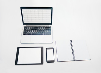 Image showing Laptop, tablet and phone mockup with notebook above for schedule planning, advertising or marketing. Computer, touchscreen and smartphone screen display for calendar reminder or organized workspace