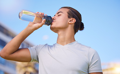 Image showing Fitness, drinking water and running with man in city for health, workout and marathon training. Relax, mindset and summer with runner jogging in outdoors for freedom, energy and exercise wellness