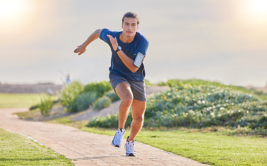 Image showing Fitness, runner in park and man running for cardio, action and energy outdoor, health and wellness in active lifestyle. Exercise, training for race or marathon, healthy and freedom with run in nature