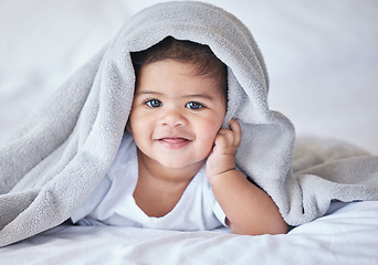 Image showing Happy, comfy and portrait of a baby on a bed to relax, sleep and rest with a blanket. Smile, cute and adorable girl child lying in the bedroom for relaxation, comfort and happiness in a house