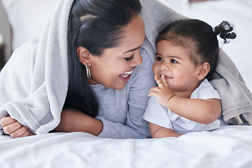 Image showing Mother, child and baby playing with woman bonding in a bed with blanket laughing being funny together in a bedroom or room. Mom, kid and single parent in a home or house with little daughter