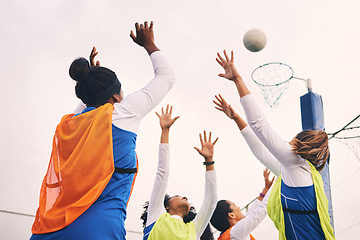 Image showing Netball, goal shooting and fitness of a girl athlete group on an outdoor sports court. Aim, sport game and match challenge of a black person with a ball doing exercise and training in a competition